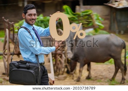 Young indian agronomist or financier showing zero percent sign or symbol at cattle farm