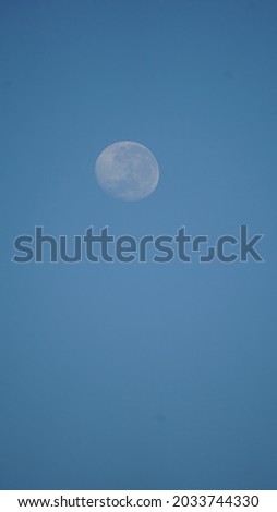 late afternoon moon against deep blue sky