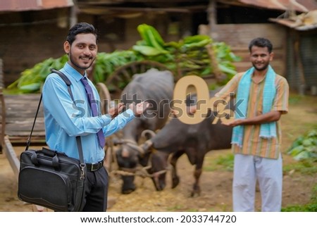 Young indian farmer showing zero percent symbol with agronomist or financier at his cattle farm