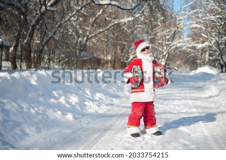 a pretty boy in a Santa Claus costume with gifts