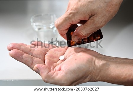 old man hand taking medicine pill from package