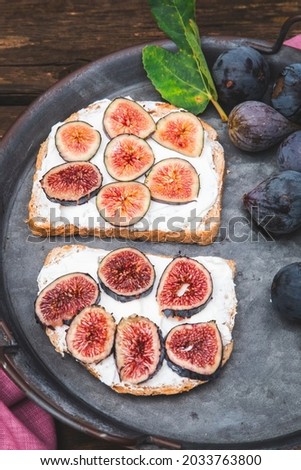 Bruschetta with soft ricotta with ripe figs served on a tray. Vertical picture