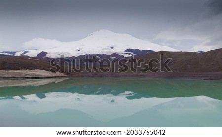 Beautiful amazing summer lake Birdzhaly in mountains. Northern country Russia Caucasus wilderness Elbrus. Inspiring panorama. Rocky landscape and cloudy sky. Nature beauty view.