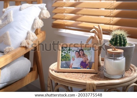 Frame with photo of lovely family on table indoors