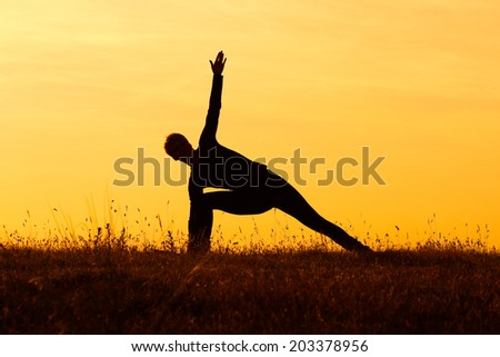 A silhouette of a woman practicing yoga,Yoga-Virabhadrasana /Rotated warrior pose