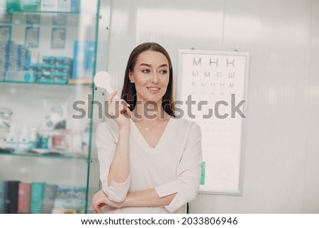 Portrait of happy young woman during eye exam at optometrist optician.