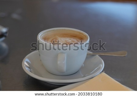 a coffee with creamy milk, served in a white porcelain cup. Coffee the most consumed drink in the world