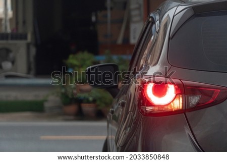 Rear side of car turn on light brake with light signal. Prepare for turn left on the asphalt. Environment in the city.
