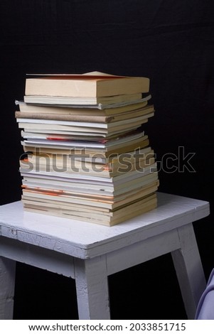 Some books are on the table on black background.