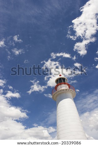white and red lighthouse against  blue sky