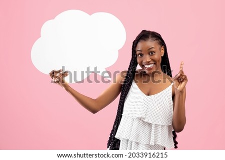 Positive black woman with afro bunches holding blank speech bubble, making IDEA gesture on pink studio background, mockup. Lovely African American lady with empty word cloud, free space