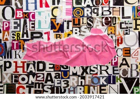Torn and crumpled piece of pink paper on collage from clippings with newspaper magazine letters and numbers. Ripped pink paper on alphabet letters cutting from magazine. Copy space for text.