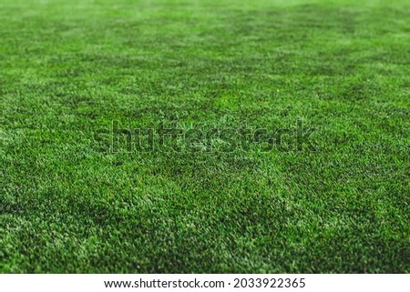 Street football outdoor game on an artificial astroturf lawn, soccer game on a pitch field with a team in a background Royalty-Free Stock Photo #2033922365