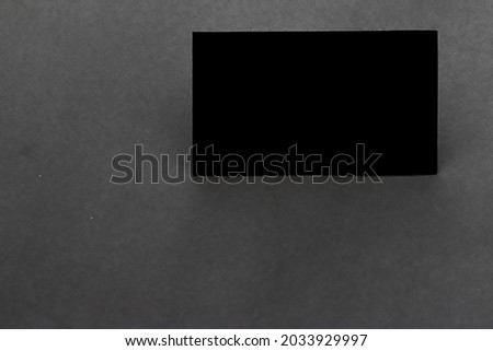 Black blank business card on dark gray background.