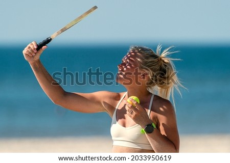 Young girl playing beach tennis on sand. Professional sport concept. Horizontal sport poster, greeting cards, headers, website.