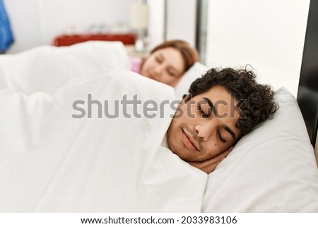 Young couple smiling happy sleeping on the bed at bedroom.