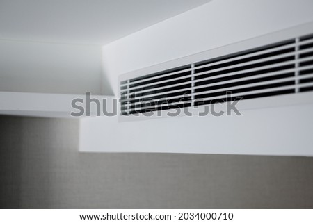 Air ventilator, metal slat frame on white ceiling. Royalty-Free Stock Photo #2034000710