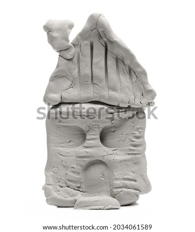 Grey modelling clay shaped in old house sculpture isolated on white background