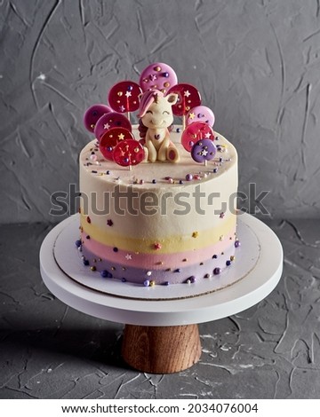 baby cake with lollipops and chocolate unicorn figurine