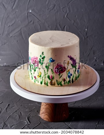 Cake with a picture of flowers on a dark background on a stand