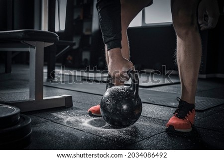Sports background. Young athlete getting ready for weight lifting training. Powerlifter hand in talc preparing to bench press.