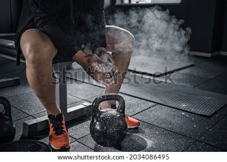 Sports background. Young athlete getting ready for weight lifting training. Powerlifter hand in talc preparing to bench press. Royalty-Free Stock Photo #2034086495