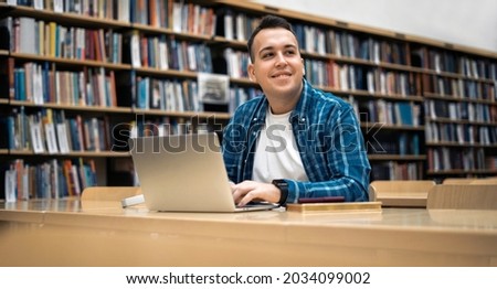 Academic year at the Institute. The student studies literature in the library at the college. She studies online on the university's website. Royalty-Free Stock Photo #2034099002