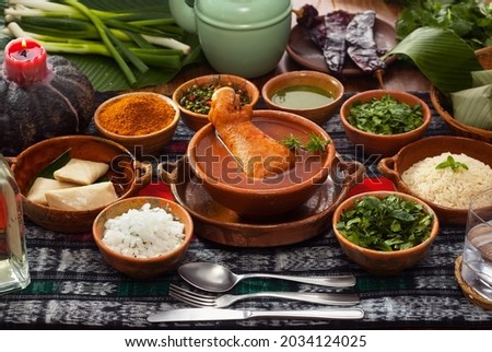 "Kak ik" traditional Guatemalan dish, made with turkey, tomato, and many aromatic herbs, served with white rice and small tamales. Royalty-Free Stock Photo #2034124025