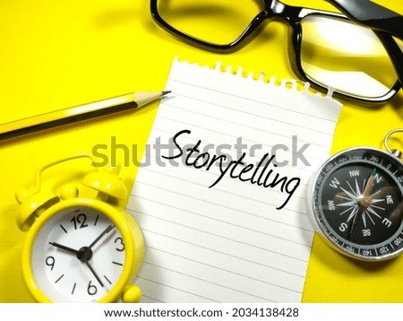Business concept.Text Storytelling writing on notepaper with clock,pencil,compass and glasses on yellow background.