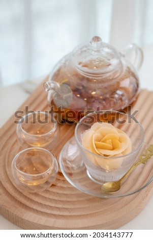 Hot tea in glass teapot and cup or earl grey tea on the white table in the white window light ambient background