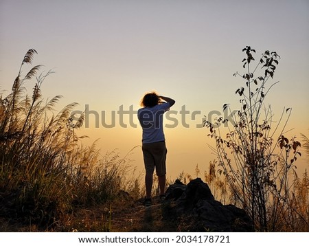adventure photography man is hiking to the top of mountain to take a picture of sunrise in autumn,backpacker are travel and go treking  photo,picture from behind Royalty-Free Stock Photo #2034178721