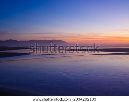 Blue ocean. Cliffs can be seen in the distance. Dust. Sunset. Peaceful calm scenes. High angle view. There are no people in the photo. There is an empty space for insertion.