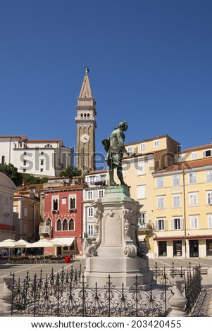 Monument of Giuseppe Tartini and the Piran church on the hill in the background