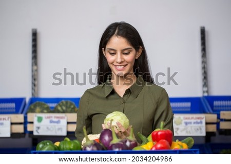 Woman in grocery aisle of supermarket stock