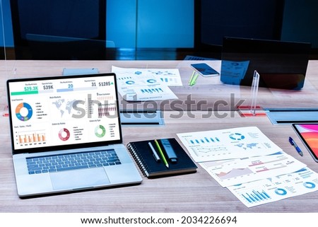 Mock up sales summary slide show presentation on display  laptop and paperwork on table with clear acrylic sheet separates the center on the conference table to prevent Covid-19 in meeting room