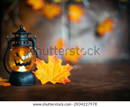 Halloween pumpkin on Autumn leaves and Jack o lantern on brown wooden background texture, Halloween,Fall and October concept copy space