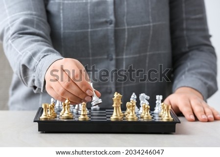 Woman playing chess on light table