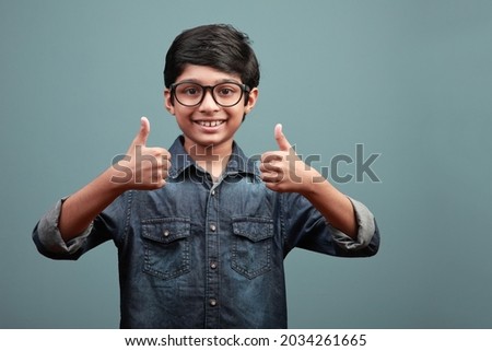 Happy boy of Indian ethnicity shows thumbs up gesture with both hands Royalty-Free Stock Photo #2034261665