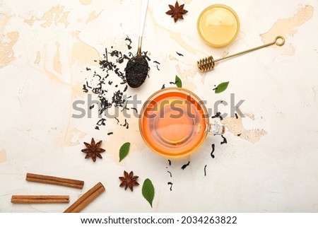 Cup of hot aromatic tea on light background