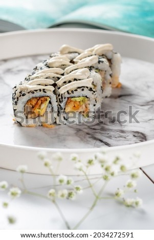 A classic sushi roll with salmon on a light marble background. Festive dinner at a Chinese restaurant
