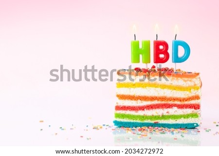 Birthday cake with happy birthday candles on a pink background with copy space for your greetings