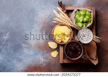 Lager beer mug, bottles, hops and wheat on old stone table. Top view flat lay with copy space