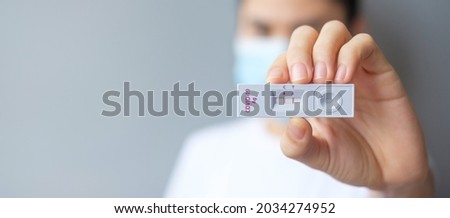 woman holding Rapid Antigen Test kit with Positive result during swab COVID-19 testing. Coronavirus Self nasal or Home test, Lockdown and Home Isolation concept Royalty-Free Stock Photo #2034274952