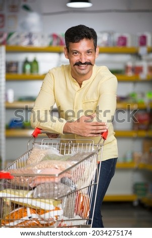 Happy man at grocery store Royalty-Free Stock Photo #2034275174