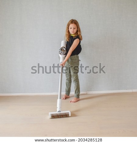 the child girl does vacuuming in the house photo without processing