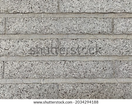 Grey oblong wall bricks with grey cement.