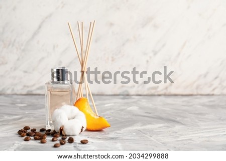 Reed diffuser on table against light background