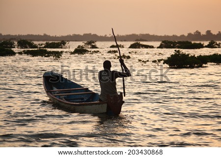 silhouette of a fisherman in the sunset, Sine Saloum delta, Senegal Royalty-Free Stock Photo #203430868