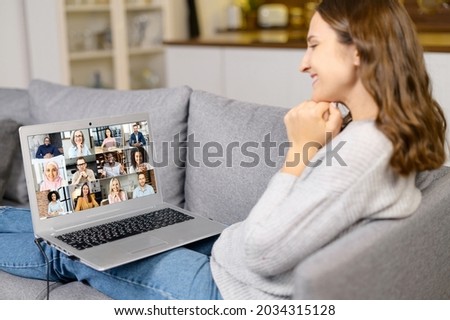 Virtual meeting with group of diverse people, young woman glad to meet friends online on the distance, laptop screen with many multiracial colleagues involved video conference