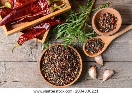 Bowls with peppercorns on wooden background Royalty-Free Stock Photo #2034330221